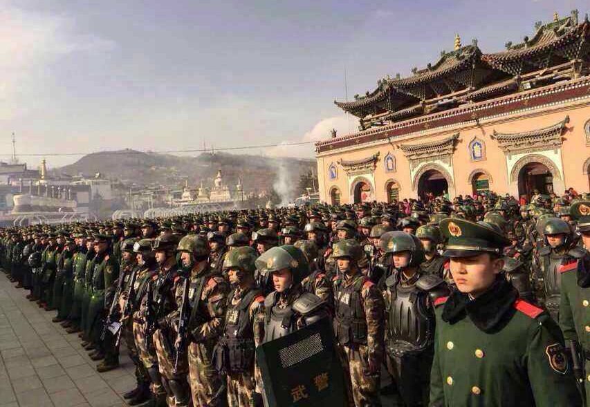 Chinese troops lined up by a Tibetan monastery