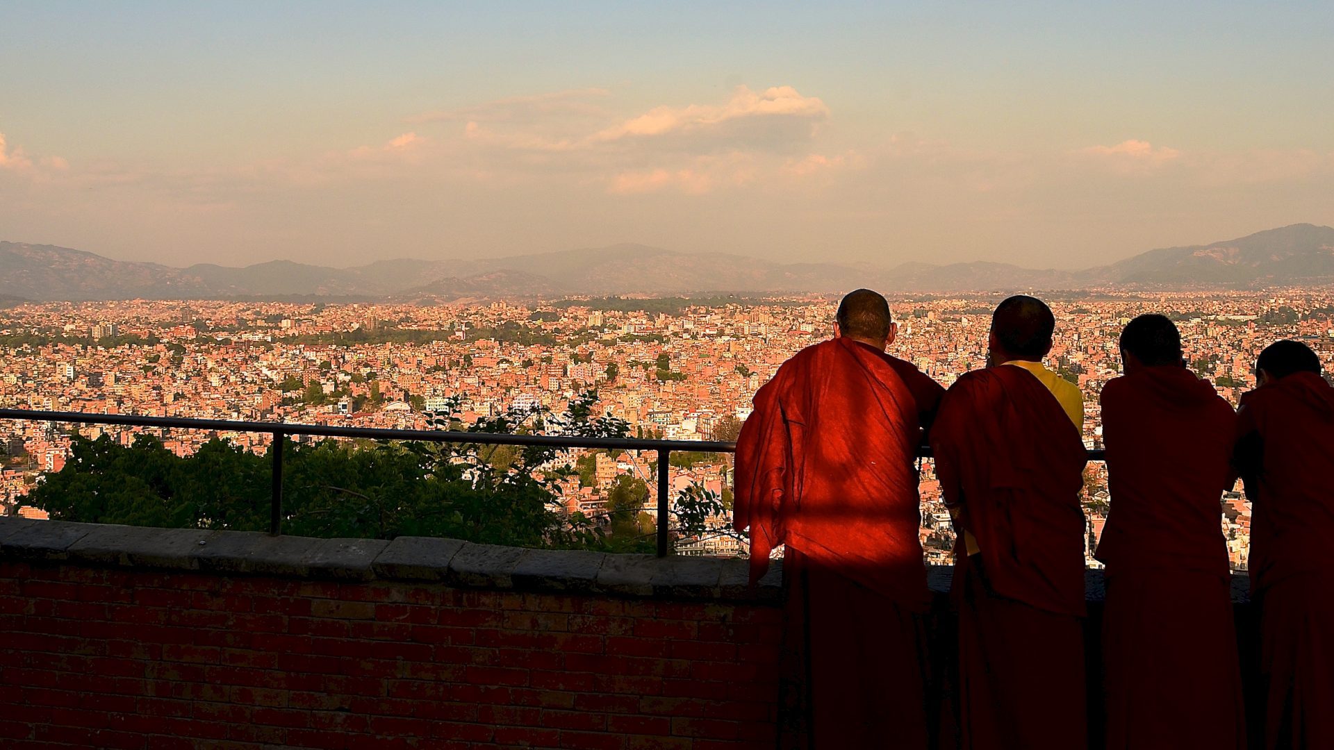 Tibetan monks looking out across the scenery