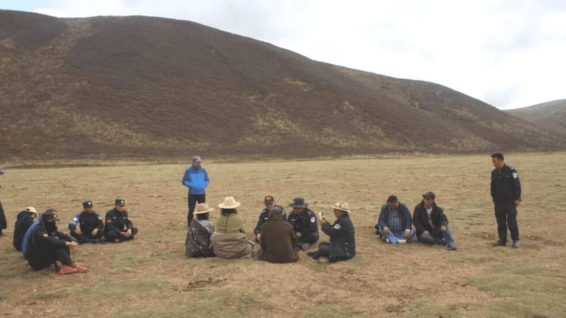 Chinese police talking to Tibetan parents outdoors