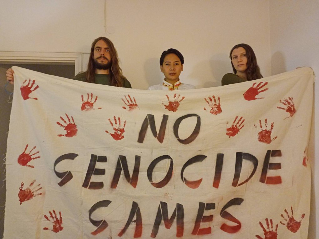 Jason, Lhamo and Fern holding a 'No Beijing 2022' banner in preparation for today's protest at the Olympic lighting ceremony
