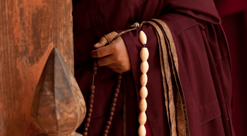 Buddhist holding prayer beads