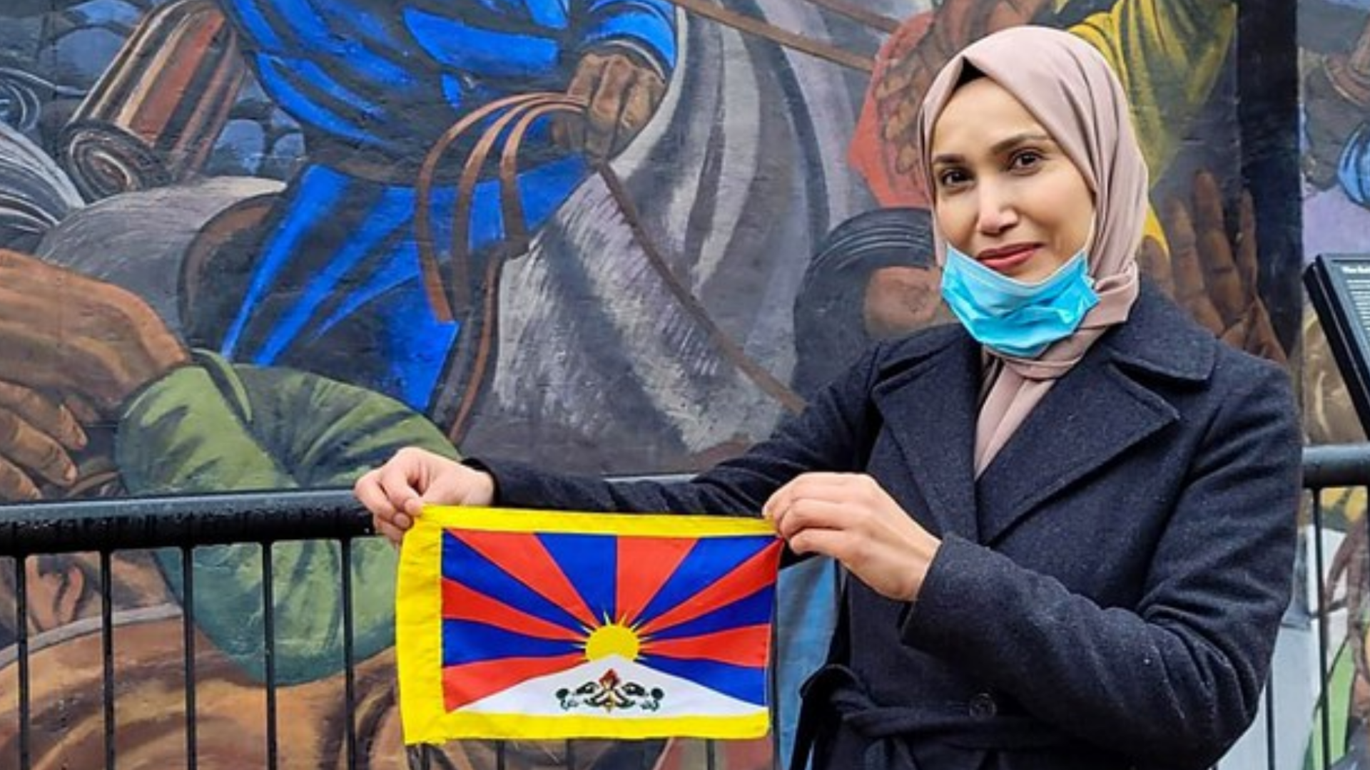 Councillor Rabina Khan holding the Tibetan flag at Cable Street, East London, on 10 March