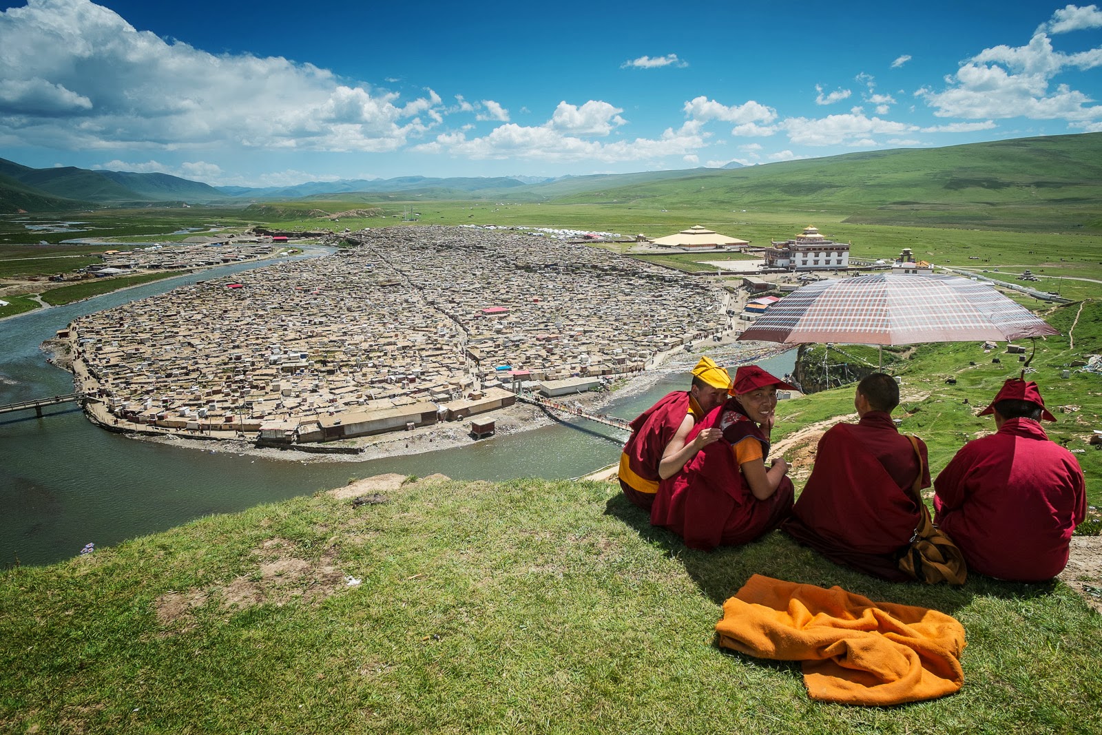 Tibetan Monks sit on a hill above the Yarchen Gar Buddhist Academy, prior to its demolition.