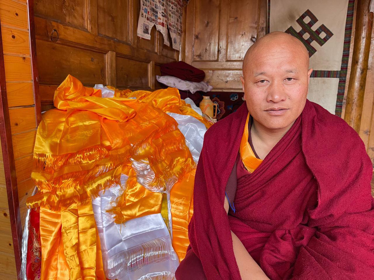 Rachung Gendun, a Tibetan monk, wearing traditional red buddhist robes.