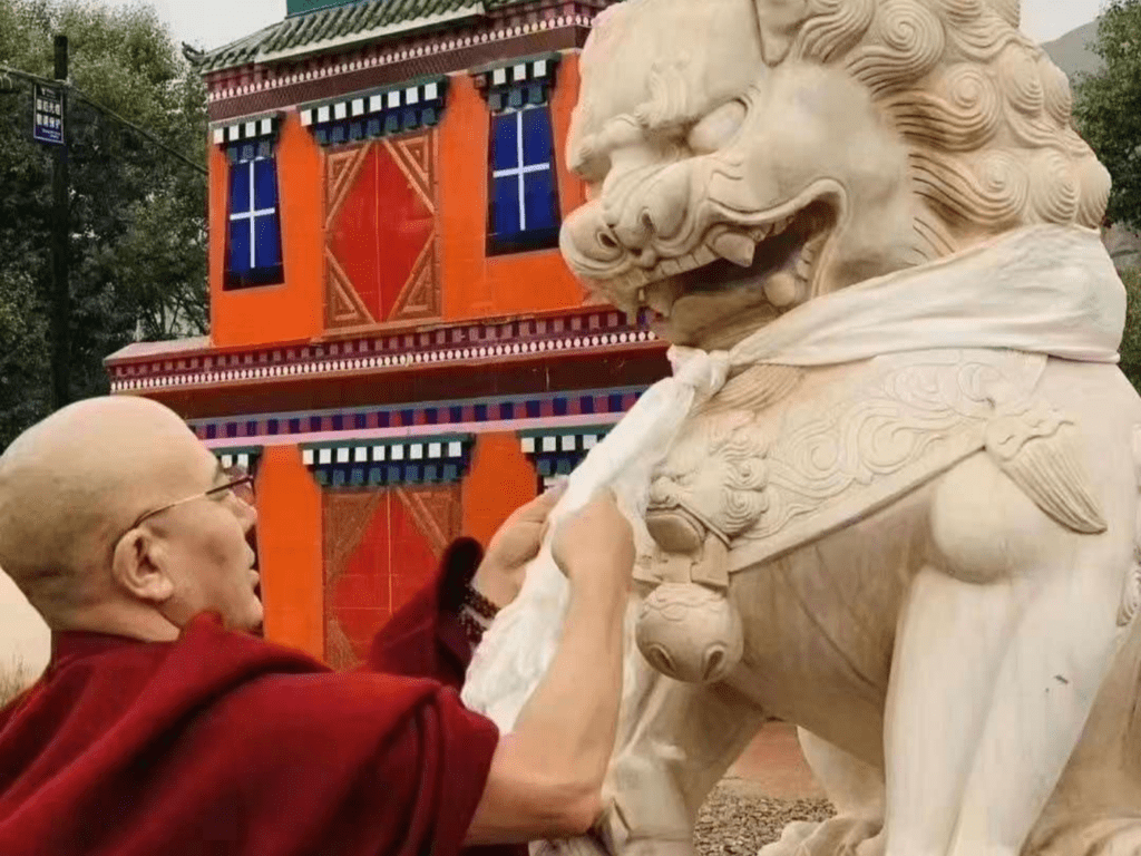 Founder of Ragya school Jigme Gyaltsen offering a farewell khata onto a snow lion at the entrance gate.