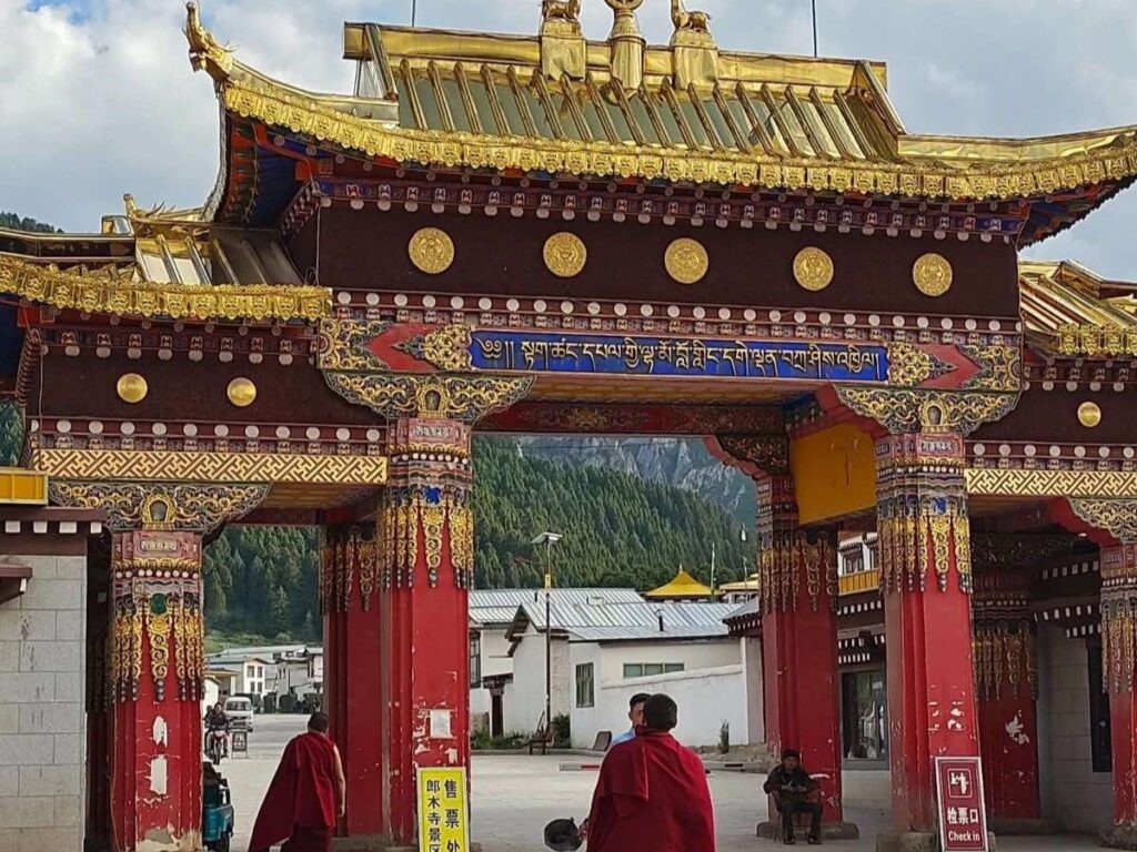 Monks enter the main gate at Taktsang Lhamo Kirti Monastery.