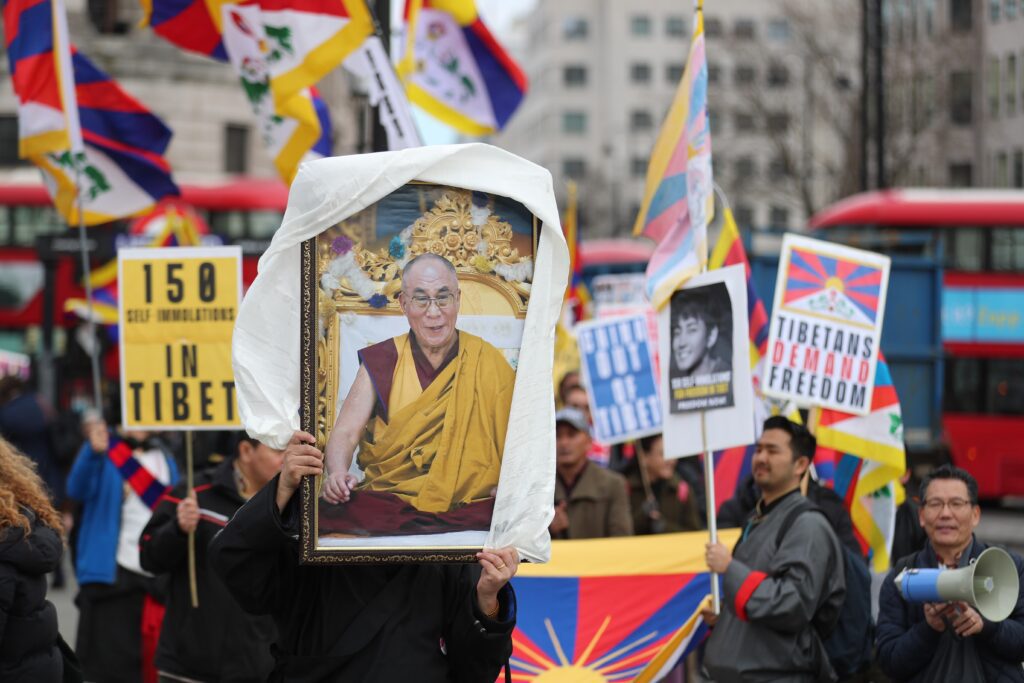 Tibetans carry a portrait of His Holiness the 14th Dalai Lama through the streets of London on Tibetan Uprising Day, 10 March 2022.